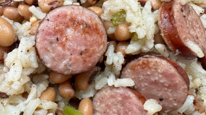 Up close photo of Hoppin John with sausage, black eyed peas, white rice, and celery.