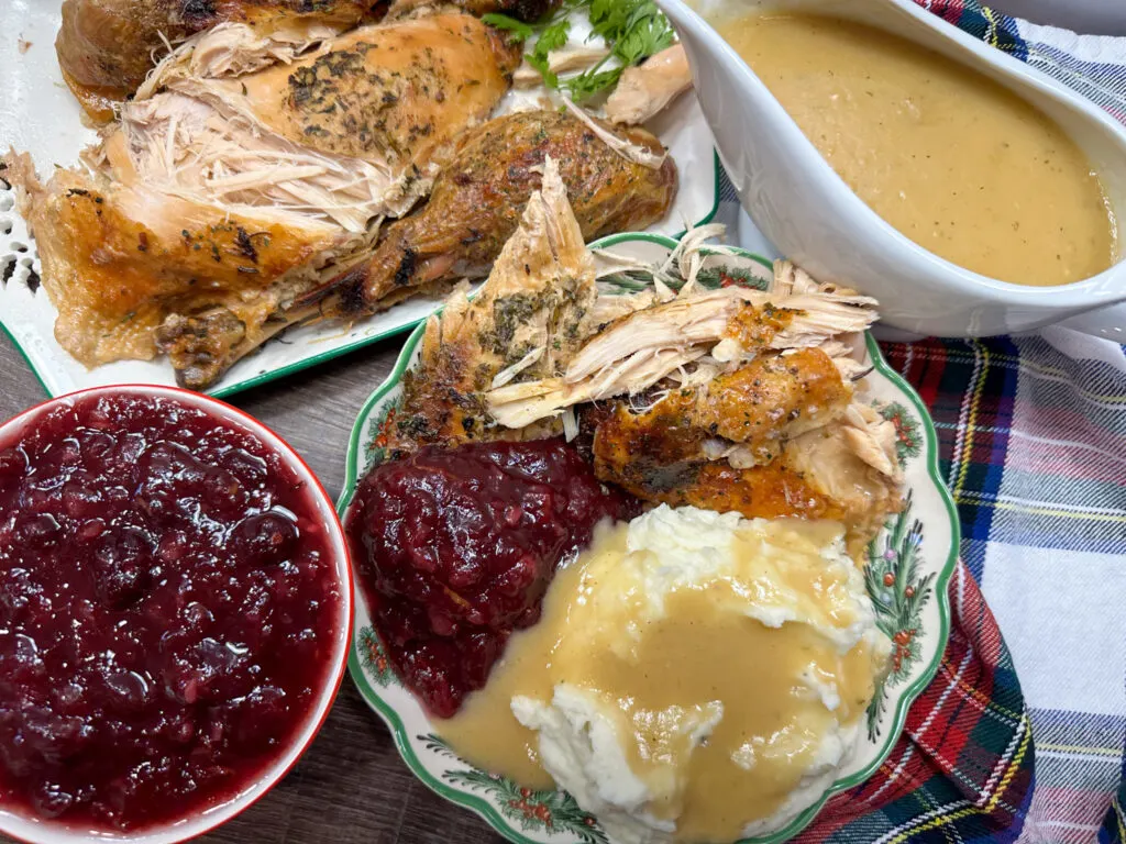Cranberry sauce on a plate with turkey and mashed potatoes.