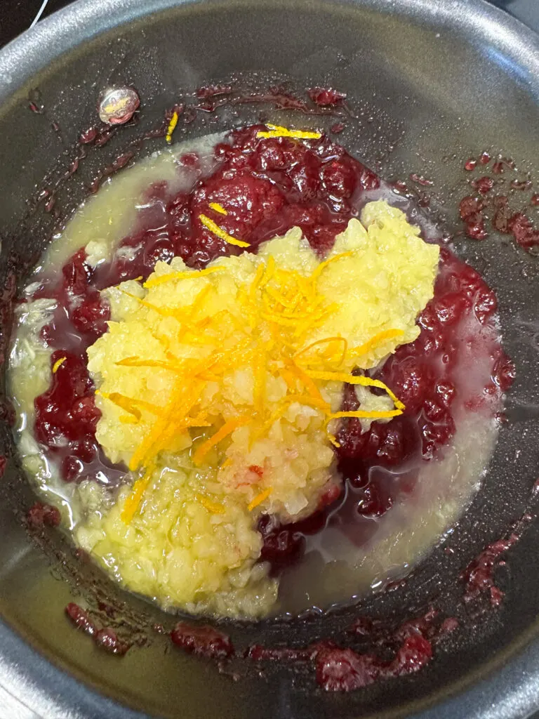 Orange zest on top of crushed pineapple and cranberry sauce.
