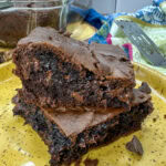 Two brownies stacked on top of each other on a yellow plate.