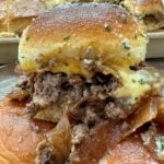 A ground beef and cheese slider. The slider is topped with caramelized onions.