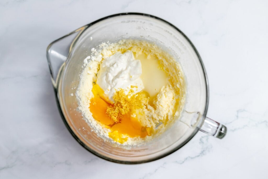 Ingredients for coffee cake in a clear glass bowl for a stand mixer.