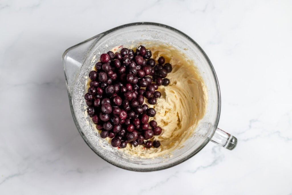 Blueberries in a large mixing bowl with coffee cake ingredients. 