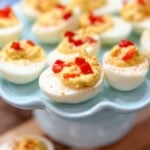 Pimento cheese deviled eggs on a blue cake plate.
