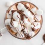 Nutella hot chocolate in a glass mug with marshmallows on top.