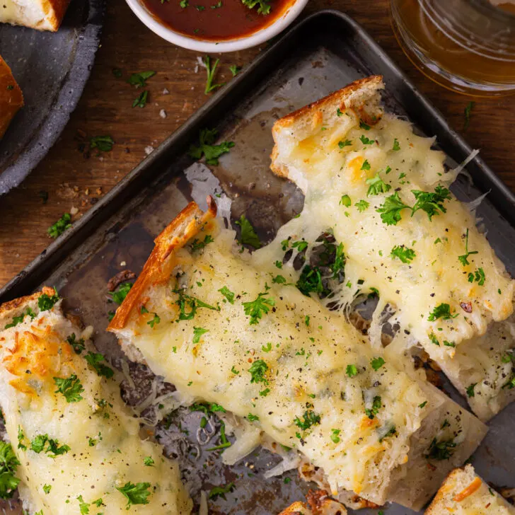 Sliced bread on a cookie sheet with dip next to it.