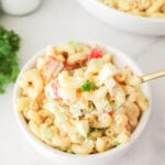 Easy macaroni salad recipe in a small white bowl with a spoon.