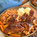 Pork ribs on a plate with bbq sauce on top.
