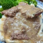 Cube steak on a plate with broccoli.