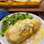 Creamy chicken breast and broccoli on a plate.