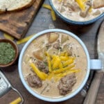 Cheeseburger soup in a bowl with shredded cheese on top.