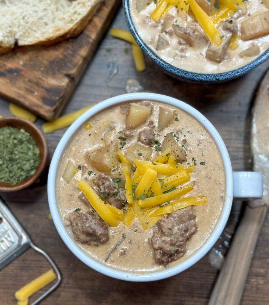 Cheeseburger soup in a bowl with shredded cheese on top. 