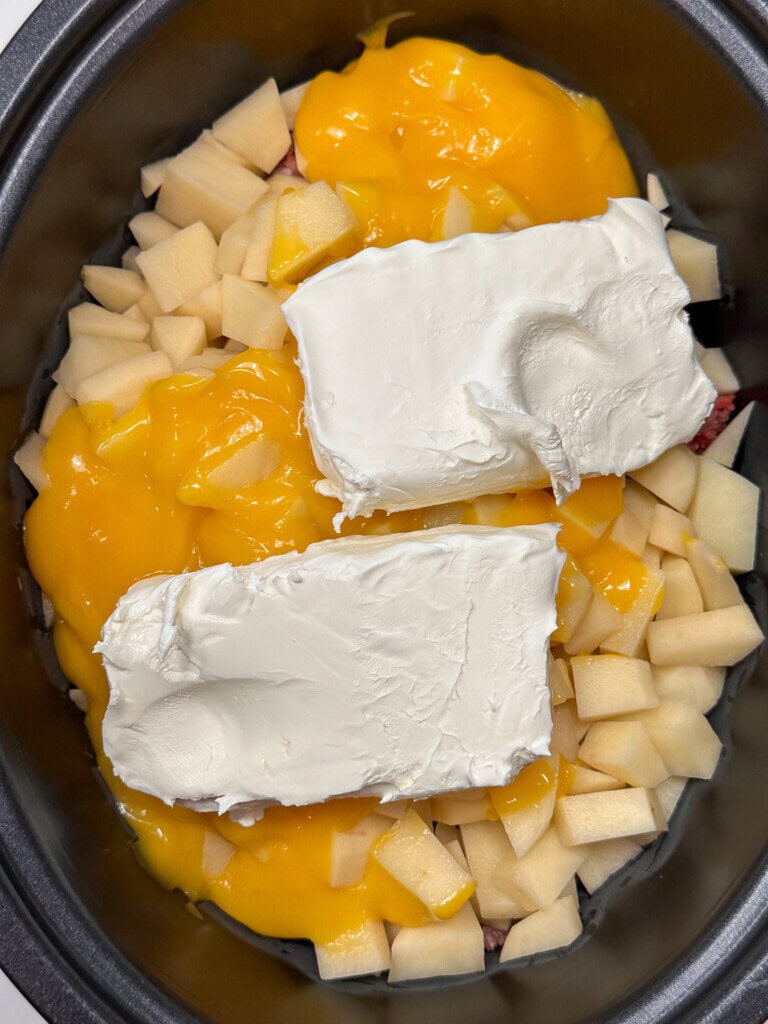 Cream cheese blocks on top of potatoes and condensed cream of cheese soup.