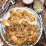 Chicken and stuffing on a plate next to some salt.