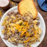 Ground beef and noodles on a plate with garlic bread