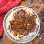 Slow cooker beef and mashed potatoes on a plate.