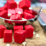 Red velvet fudge in a bowl and on a cutting board.