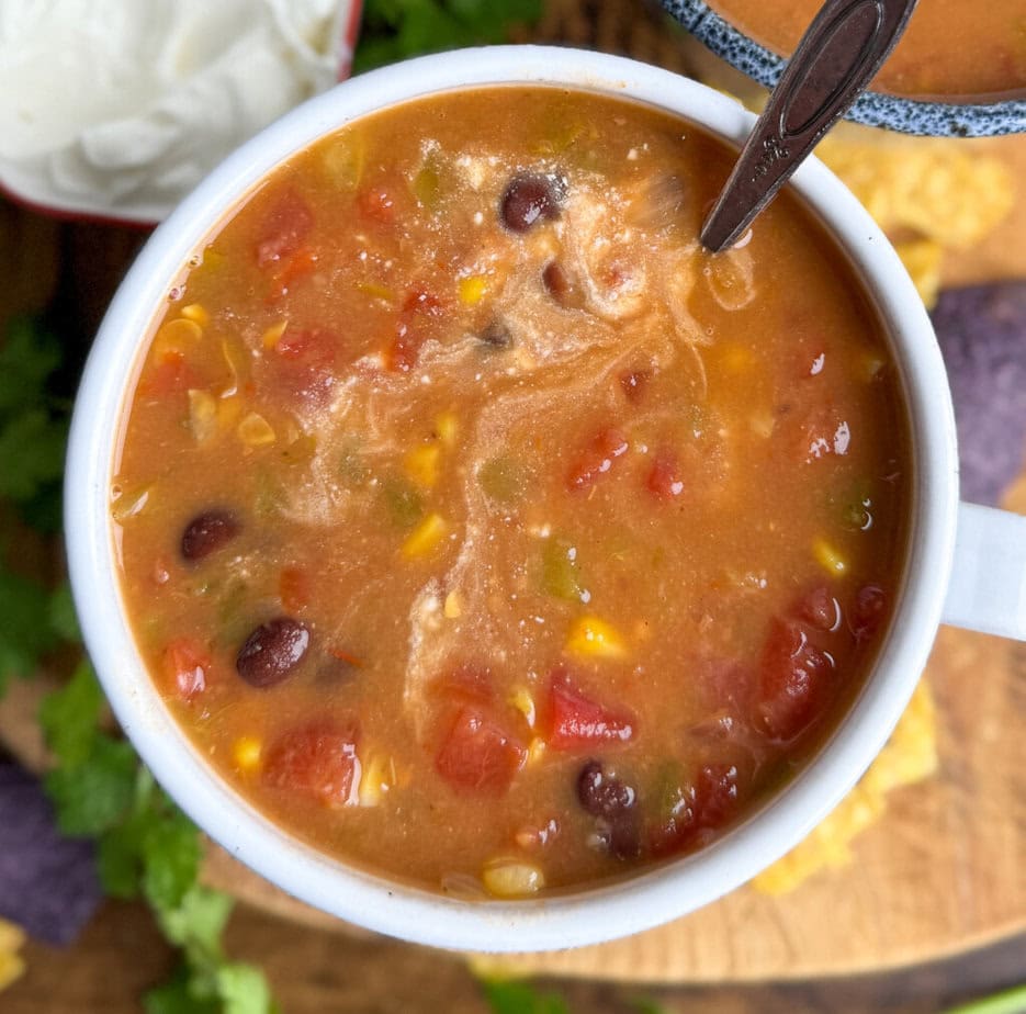 Bean soup in a white bowl. There is a spoon in the bowl.