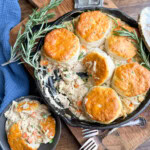 Chicken pot pie in the skillet next to a bowl with the pot pie.
