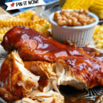 Barbecue chicken breast with Sweet Baby Ray’s sauce, served with fries, baked beans, and corn on the cob, on a plate. Text on image reads “5-Ingredient Sweet Baby Ray’s Crock Pot Chicken.”.