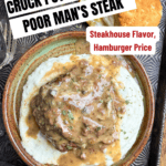 A plate of mashed potatoes topped with hamburger steak and brown gravy, garnished with herbs. A biscuit, dried herbs, and a fork sit nearby. Text reads: “6-Hour Crock Pot Poor Man’s Steaks with Mushroom Gravy—Only 5 Ingredients!”.