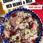 A bowl of crock pot sausage, red beans, and rice sits on a table with a slice of cornbread. Text on the image highlights the dish as “Crock Pot Sausage Red Beans & Rice,” “Dump and Go!” and “Only 6 ingredients!”.