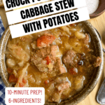 A hearty bowl of Crock Pot Beef and Cabbage Stew with Potatoes sits on a wooden table, accompanied by a spoon and slices of bread with butter. This easy crock pot recipe is the perfect comfort meal for any night of the week.